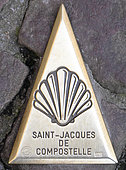 Bronze spire depicting a Saint Jacques shell inlaid in the cobblestones, indicating the direction of the pilgrimage route of Compostela, Saint Jean Pied de Port (64), Pyrenees, France