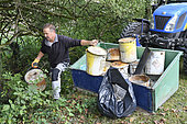 Collecting of a wild depot of paint cans in the ditch of a canal, France