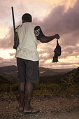Hunter holding a Insular flying fox (Pteropus tonganus) killed with a shotgun. Endemic species. New Caledonia.