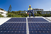 Worker cleaning solar panels, New Caledonia.