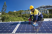Worker cleaning solar panels, New Caledonia.