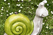 Snail on a decorative snail in a garden, spring, Pas de Calais, France