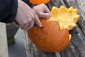 Little girls making a Halloween pumpkin