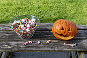 Little girls making a pumpkin for Halloween, jar of candy and pumpkin