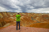 Tourist photograph, Eroded hills of sedimentary conglomerate and sandstone, Unesco World Heritage, Zhangye, China