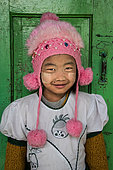 Burmese girl with her pompom cap, photographed in front of her classroom in the city of Nyuang U. On these cheeks, tanakha powder, to protect from the sun.