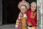 Little Russian girl and her brother in the town of Uglish in traditional dress at a village party