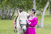 Mongol woman traditionnaly dressed with a horse, Mode, Bashang Grassland, Zhangjiakou, Hebei Province, Inner Mongolia, China