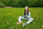 Young girl during a macro photo shoot in a meadow in the Queen Forest, Lorraine, France