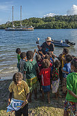 Tara Pacific expedition - november 2017 Tara at anchorage near local village, Normanby Island, papua New Guinea, Captain Simon Regal distributing educative brochures upon arrival.