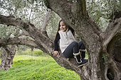 Alessandra, 7, poses in a several hundred years old olive tree in Kritsa, Crete, Greece