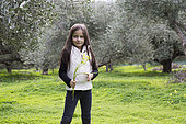Alessandra, 7, picks Bermuda buttercup in an olive grove in Kritsa, Crete, Greece