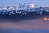 Mont-Blanc et brume au crépuscule. Massif du Mont-Blanc au crépuscule. En premier la brume est illuminée par la lumière crépusculaire et la lumière des villes. Alpes, France