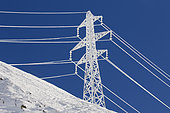 Frozen high voltage line, pylon, and snow in the Valais Alps, Switzerland.