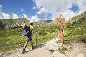 Young hiker at the intersection of the Prals Lakes Trail, Orientation Pillar, Fenestre de la Madone Valley, Haute-Vésubie, Mercantour National Park, Alpes-Maritimes, France