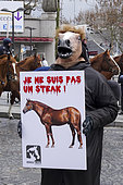 Costumed activist holding a protest sign in front of and during the agriculture show in Paris, France
