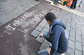 Activist writing a message with chalk on the ground during an anti-hunting demonstration, Paris, France
