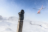 Unloading of the Astrolabe by helicopter on the Dumont D'urville base. Bust of Paul Emile Victor, Terre Adélie, Antarctica