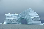 Arch in an iceberg in Scoresbysund, North East Greenland