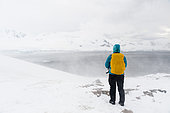 A snowstorm hits a tourist watching the landscape in Neko Harbour, Antarctica.
