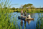iSimangaliso Wetlands Park. Visitors crossing a river with a local raffia boat. Santa Lucia. Kwazulu Natal. South Africa.