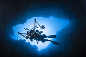 Inside the reef. Underwater photographer in an underwater cave, Misool, Raja Ampat, Indonesia