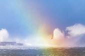 Waves hitting the lighthouse of the Carnot dike with a rainbow created by reflection of light on the waves, during the storm Ciara, Boulogne sur mer, February 2020, Hauts de France, France