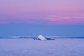 La montagne Môle émerge d‘une mer de nuages au crépuscule du matin. Prise de vue depuis la station de Flaine. Haute-Savoie, France En arrière plan, la chaine du Jura.