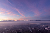 Cirrus homogenitus and air pollution at dusk, in Geneva, on January 08, 2020. Persistent contrails lit by the sun. View from Mont Salève, Haute-Savoie, France