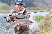 Fly fishing in a reservoir, Presentation of a rainbow trout (Oncorhynchus mykiss or Salmo gairdneri), Moselle, Lorraine, France