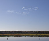 Unusual circular cloud over lake, most likely the vapour trail from a plane, Myakka River State Park, Florida, USA
