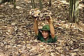 Vietnamese soldier gliding into the entrance of the Viet Cong tunnel system in Cu Chi, Vietnam, Asia
