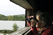 Girl observing birds through binoculars, Étang de la Véronne, Etangs du Malsaucy et de la Véronne trail, Sermamagny, Territoire de Belfort, France