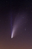 Comet Neowise in the night sky. Its bifid tail is made of ions (blue) and dust and water (white plume), France