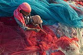 Fisherman repairing fishing nets, Varkala, Kerala, India, Asia