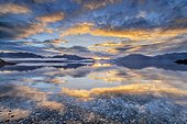 Light beam of golden cloud atmosphere over Lake Te Anau, in the background mountain ranges of the Stuart Mountains and Franklin Mountains, Fjordland National Park, Te Anau, Te Anau, Southland, New Zealand, Oceania
