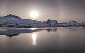 Sun ring, halo over snowy mountain range, arctic winter landscape, in front sea, ballangen, Nordland, Norway, Europe