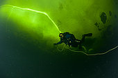 Scuba diver under ice and ice formation, Arctic circle Dive Center, White Sea, Karelia, northern Russia