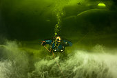 Scuba diver under ice in a halocline cloud, a subtype of chemocline caused by a strong, vertical salinity gradient within a body of water. Arctic circle Dive Center, White Sea, Karelia, northern Russia