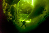 Scuba diver under ice and ice formation, Arctic circle Dive Center, White Sea, Karelia, northern Russia