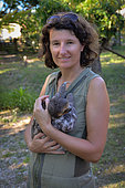 Woman holding a young Pale-throated three-toed sloth (Bradypus tridactylus), French Guyana
