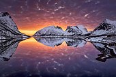 Aerial view, dramatic cloud atmosphere at sunset over Nordfjorden, Bergsbotn, snow-covered peaks of Luttinden and Snaufjellet reflected in the calm sea, Senja Island, Troms, Norway, Europe