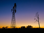 A windmill (windpump) against a beautiful dawn sky at the tiny Karoo town of Freserburg. Northern Cape. South Africa.