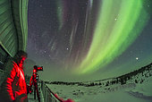 A photographer shooting an all-sky aurora display in the early morning hours on February 10, 2018, from the upper deck of the Churchill Northern Studies Centre, Churchill, Manitoba, Canada. Visually, the aurora was dim and colourless. Kp Index was 1. This is looking northeast with Jupiter rising at far right. 
