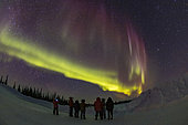 March 19, 2020 - A group of staff and volunteers at the Churchill Northern Studies Centre enjoy the northern lights show. The aurora shows the classic lower green arc topped by tall curtains of red, all from oxygen atoms. 
