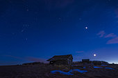 March 26, 2020 - The setting waxing crescent moon below Venus which is below the Pleiades star cluster. At top centre is the Hyades star cluster and Aldebaran in Taurus. At left is Orion sinking into the twilight of a spring evening. The setting is an old farmstead in Alberta, Canada.
