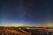 December 3, 2019 - Orion and the winter stars rising in the light of a waxing moon. This was from a viewpoint overlooking the Bow River on the Siksika Nation in southern Alberta, Canada. Orion is above the river with Sirius in Canis Major just rising. Aldebaran and the Hyades in Taurus are at top. At left are Castor and Pollux in Gemini. Above the lights is Procyon in Canis Minor. The Beehive Cluster in Cancer is at far left. . The low moon behind the camera to the right added a warm bronze hour tint to the landscape.
