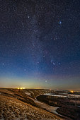 Orion and the winter stars and constellations rising in the light of a first quarter moon on December 3, 2019. The vertical format sweeps up the Milky Way. . . This was from a viewpoint overlooking the Bow River on the Siksika Nation in southern Alberta, Canada. . Orion is above the river with Sirius in Canis Major just rising. Aldebaran in Taurus and the Pleiades are at top right. At top is the star Capella and the constellation of Auriga. At left are Castor and Pollux in Gemini. Above the lights is Procyon in Canis Minor. The Beehive Cluster is at left. . The low moon behind the camera to the right added a warm bronze hour tint to the landscape.
