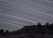 Star trails created by the Earth's spin arch over a cross on the hill at Camp Billy Joe, Oklahoma.