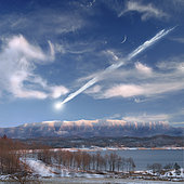 An artist's depiction of a large meteor entering Earth's atmosphere and about to impact in a mountainous area.